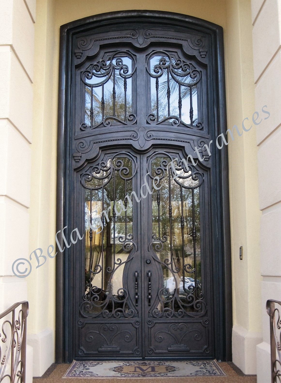 Bella Grande Entrances has crafted a magnificent iron door for a grand entrance in Las Vegas. This tall and elegant door features a twisted pull, inner glass, and a large iron grill at the top. A true masterpiece of craftsmanship.