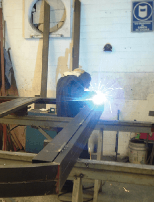 A skilled individual expertly welding a piece of metal for the fabrication of an iron door.